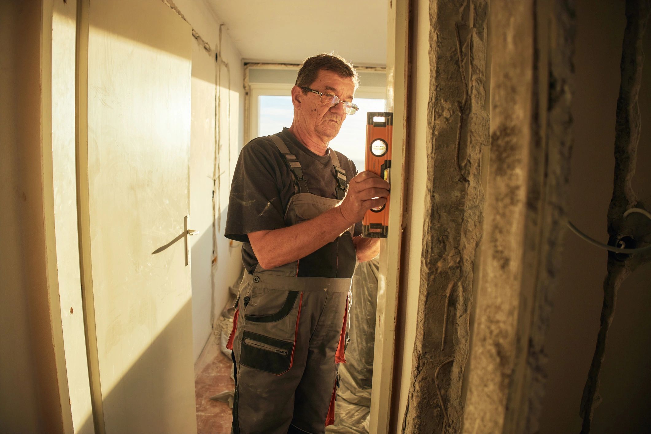 Tradesperson measuring and checking a wall during refurbishment work